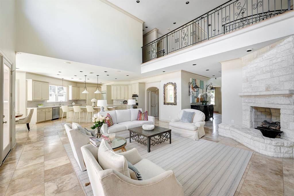 Light-filled great room with soaring ceiling and kitchen in the background