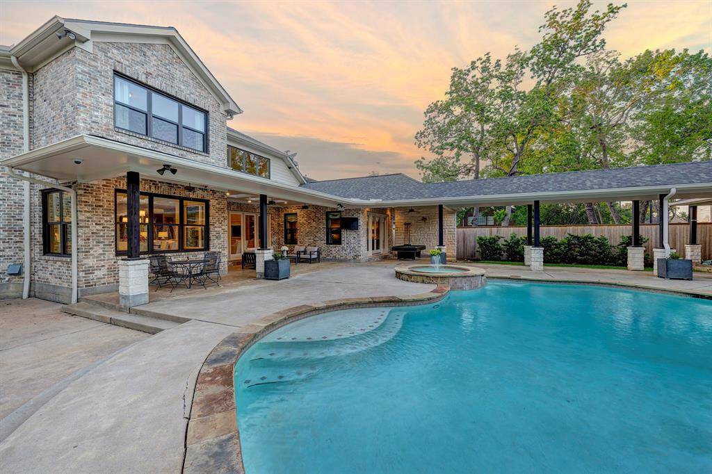Fabulous outdoor space with pool, lounging area, pickleball area and an oversize lawn