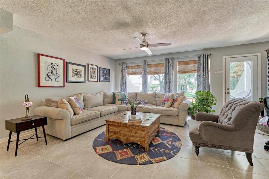 Open den with beautiful wall of windows and glass door leading to back deck!