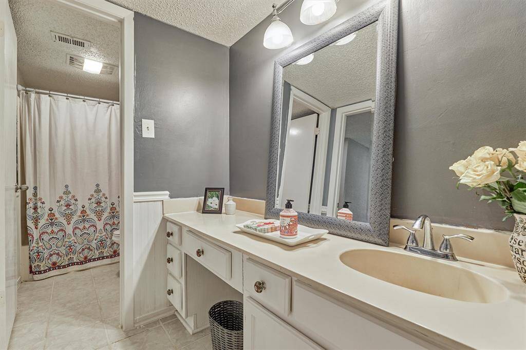 Lovely bath in neutral gray with vanity, updated lighting, fixtures and tub/shower combo.