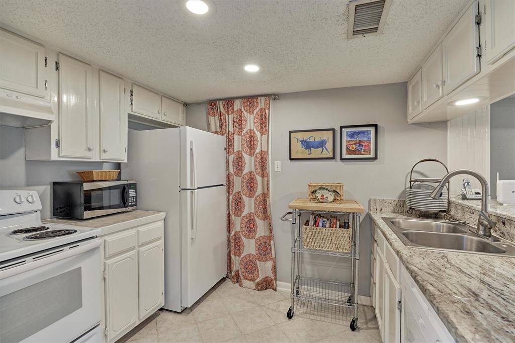 Light and bright, galley kitchen with granite countertops and white cabinets!