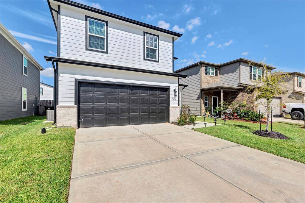 Another view of the exterior of the home, 2 car garage and a big driveway.