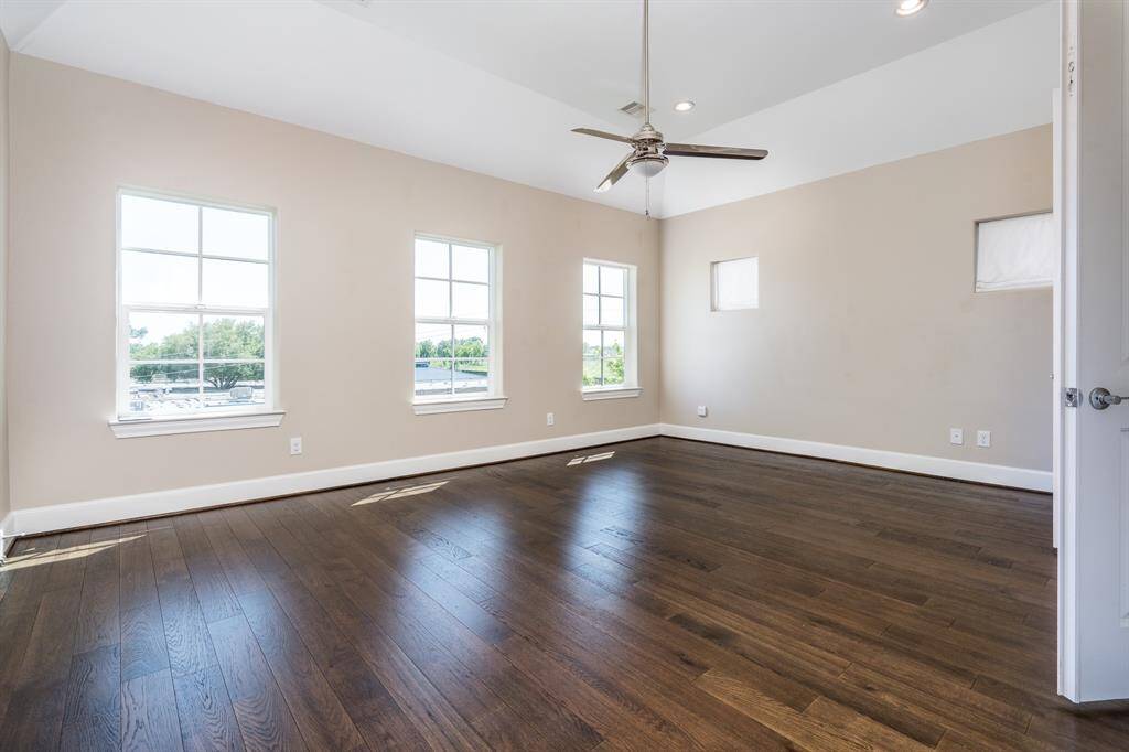 The primary bedroom is filled with natural light from tons of windows.