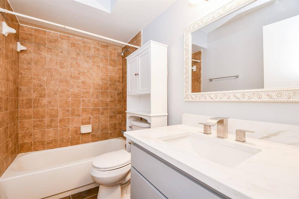 1st floor secondary bathroom with beautiful framed mirror and plumbing hardware.