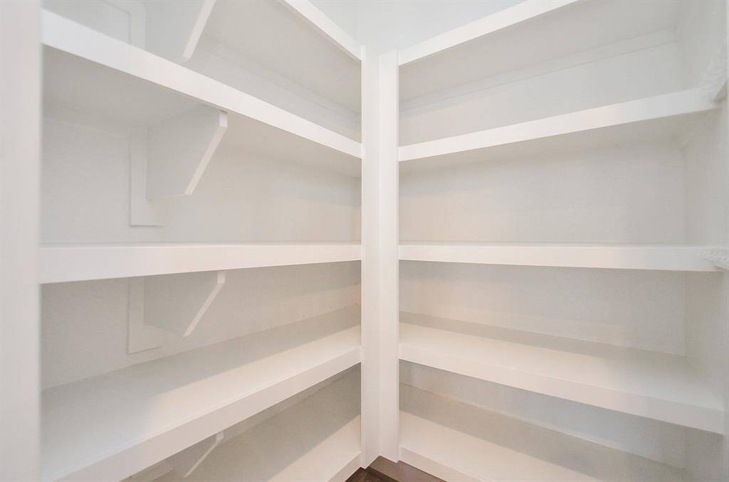 Step into this spacious pantry with ample shelving, perfect for organization.