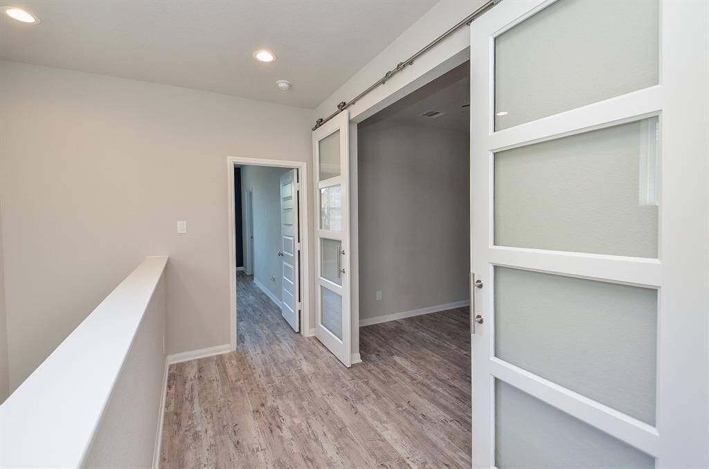 Notice this entry to the next room with stylish sliding doors with glass panels.