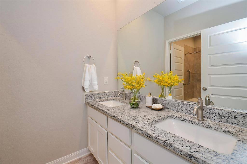 Notice the spacious double vanity featuring elegant granite countertops and dual under-mount sinks.