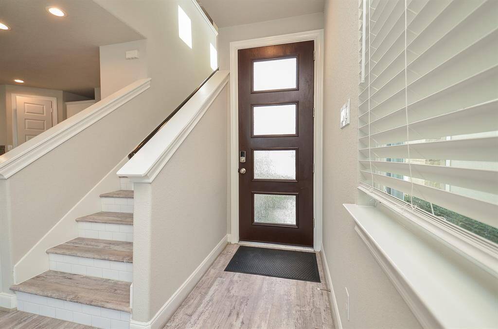 Step into this bright and airy entryway. Notice the elegant staircase leading to the upper level, hinting at the comfortable living spaces that await.