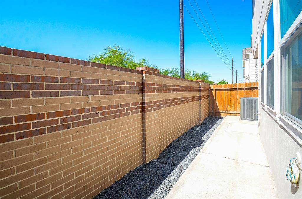 Step outside in the back with this gorgeous brick wall, perfect for privacy.