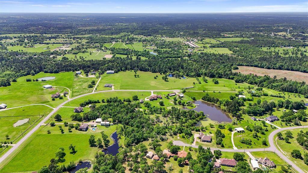 This aerial photo showcases a spacious rural landscape, lush greenery, and several small lakes, providing a serene and expansive environment ideal for privacy and nature enthusiasts.