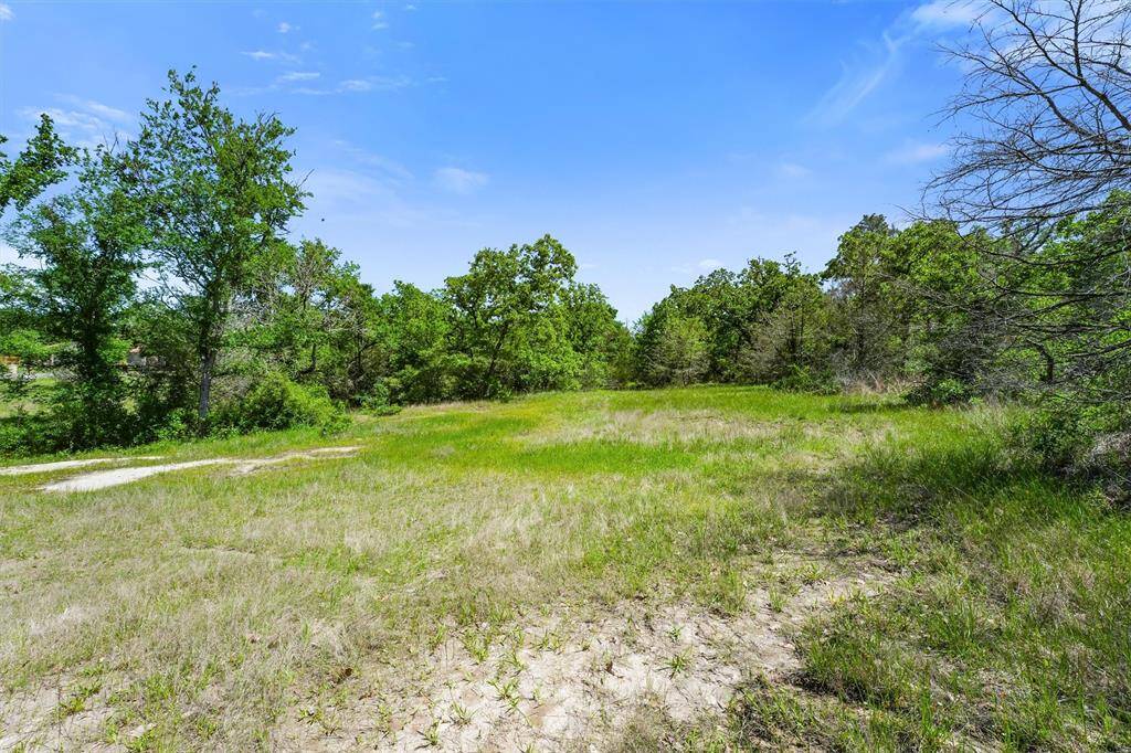 Expansive cleared homesite nestled on a serene 5-acre lot—an ideal canvas for your custom dream home. Surrounded by mature trees along the perimeter, this open space offers privacy, natural beauty, and endless possibilities for your future estate, pool, or barn. Utilities nearby and ready for development.
