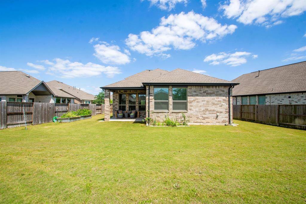 The yard is enclosed by a wooden fence, providing privacy and a safe space for outdoor activities.