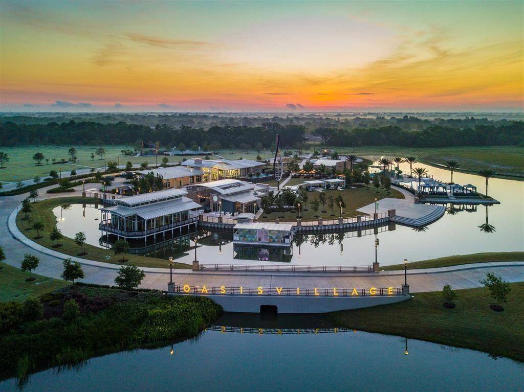 Meridiana is a picturesque community, and this picture showcases it's modern lakeside living with sleek architecture, lush landscaping, and tranquil water views, perfect for serene living.