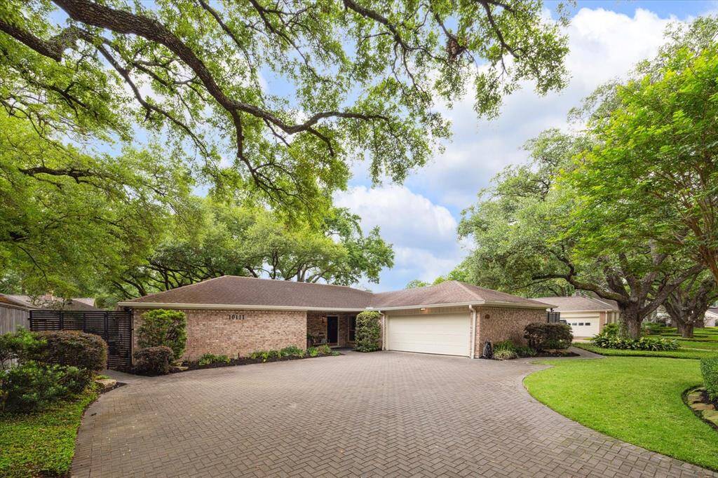 The property features a spacious, paved driveway and well-maintained landscaping which enhances curb appeal