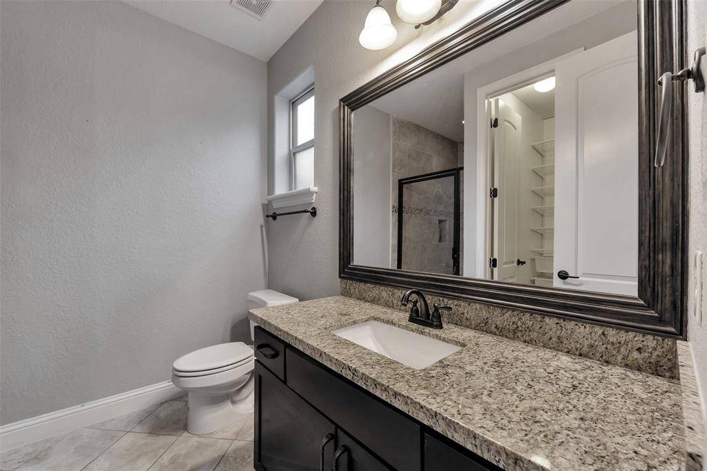 Granite countertops and plenty of under sink cabinets for storage are featured in this ensuite bath on the first floor.