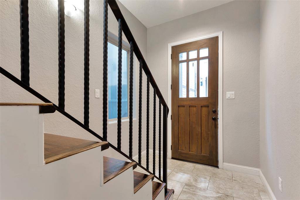 The front door to the home opens to an entryway with a window and a hallway. The stairs take you to a beautiful living room, dining room, kitchen, and half bath.