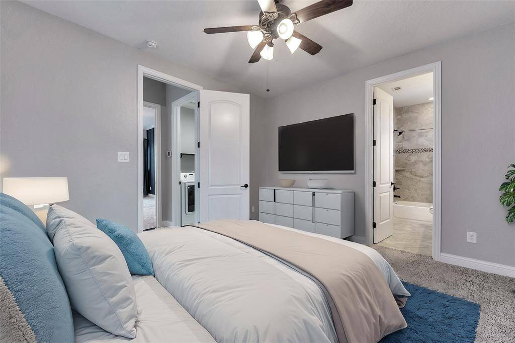 This is the secondary bedroom across the hall from the primary bedroom. The door in the middle leads to the ensuite third full bath. You can catch a glimpse of the utility room right outside.