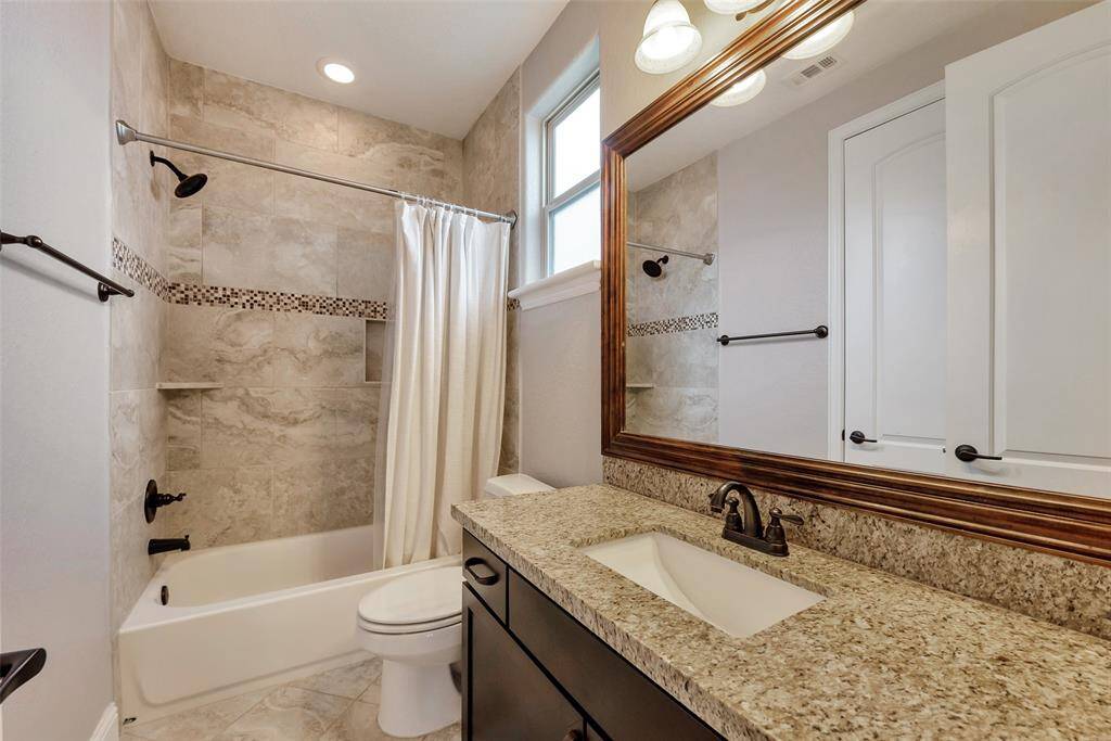 The ensuite third full bath features a tub/shower combination and plenty of cabinets for storage under the sink.