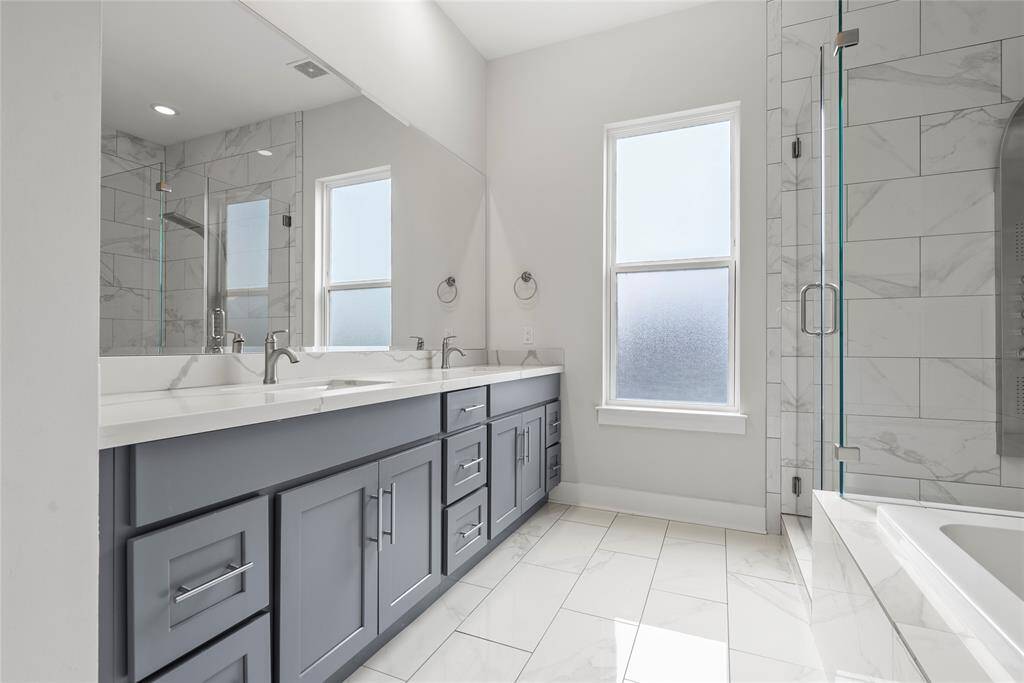 Double sinks with quartz countertops and beautiful cabinetry which allow tons of storage