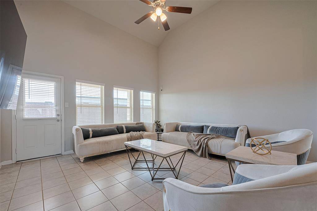 This airy gathering space impresses with soaring ceilings, abundant natural light, and a ceiling fan. Seamlessly connected to the kitchen and dining areas, it’s designed for both comfort and connection.