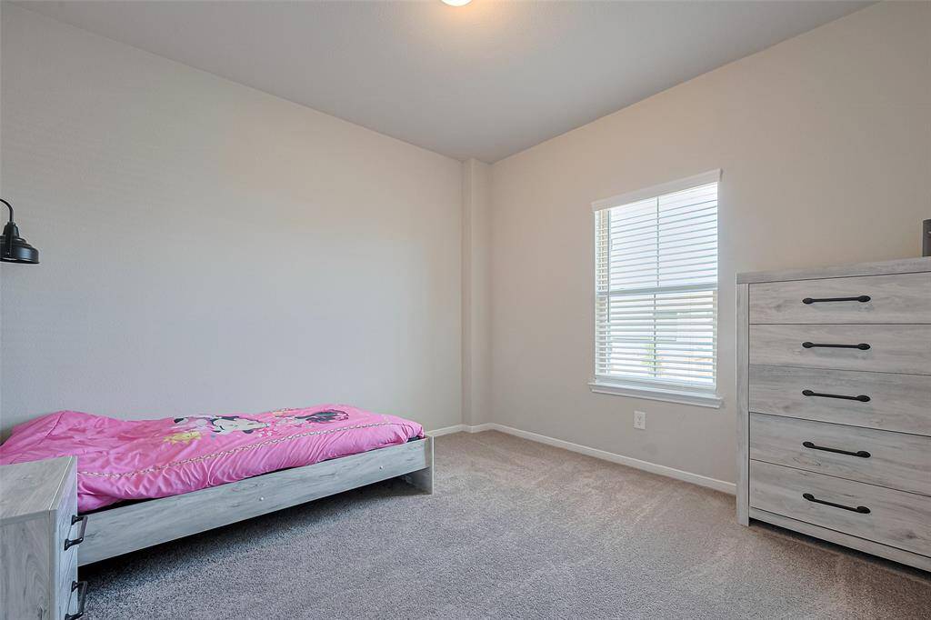 With calming tones and soft textures, this bedroom provides a peaceful escape. Ample floor space and a large window make it as functional as it is cozy.
