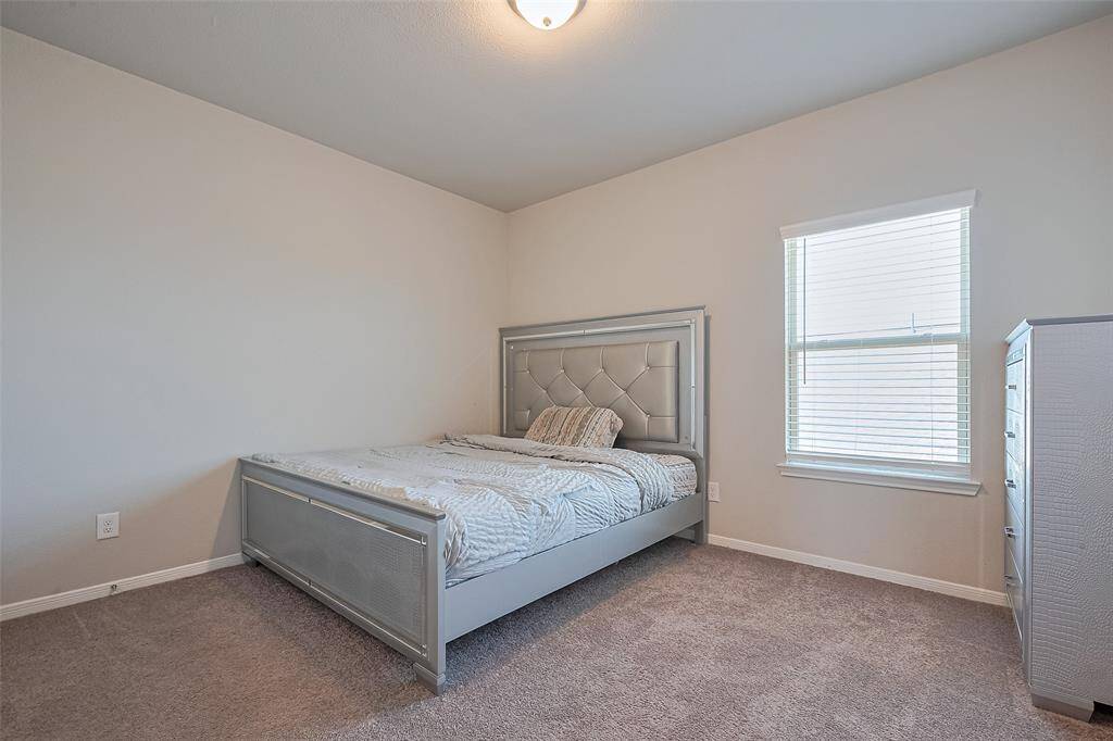Another well-sized sleeping space finished in warm neutral tones, this room features a generous window and soft carpeting—ideal for rest or flexible use.
