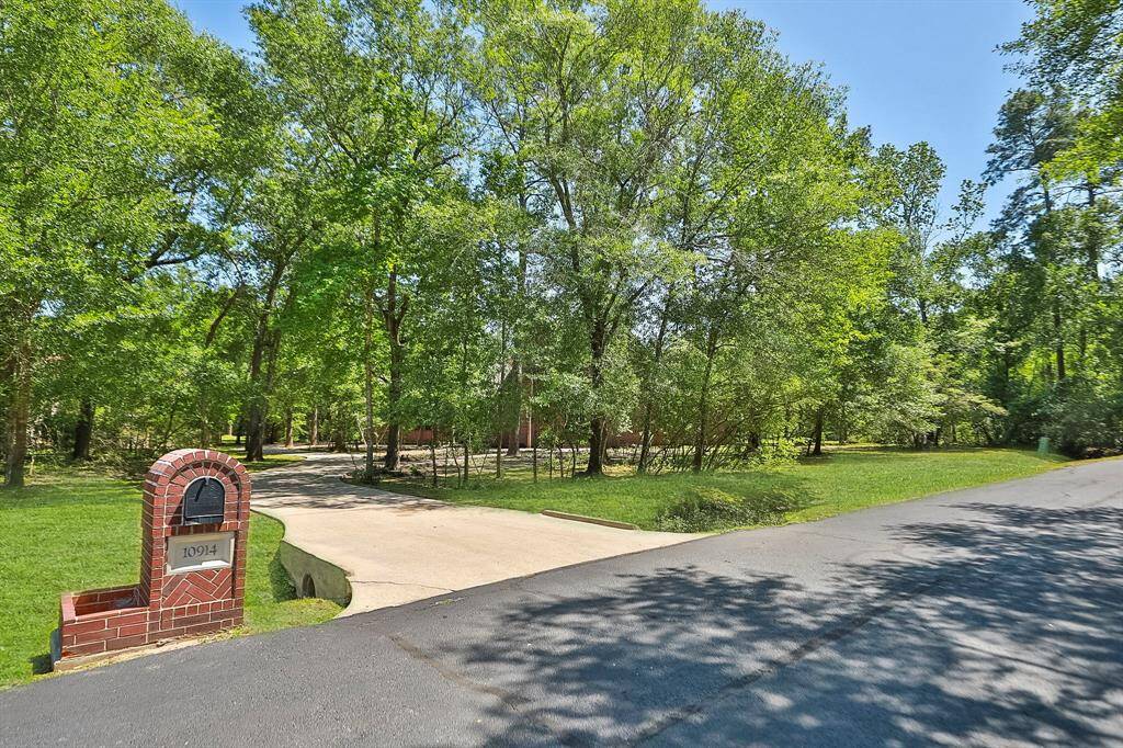 Set amidst a lush, wooded landscape, this home features a welcoming front entrance and a serene, natural setting perfect for privacy and tranquility