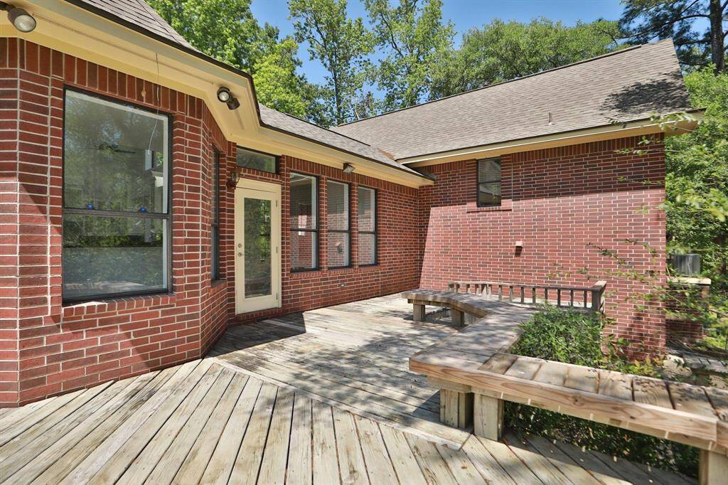 Step out onto the wooden deck, ideal for outdoor relaxation. Surrounded by lush greenery, the large windows offer plenty of natural light, creating a warm and inviting atmosphere.