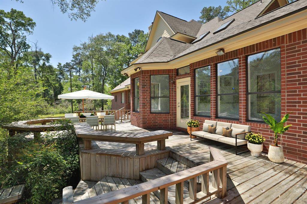 Virtually staged deck area overlooking the private, wooded acreage of the property.