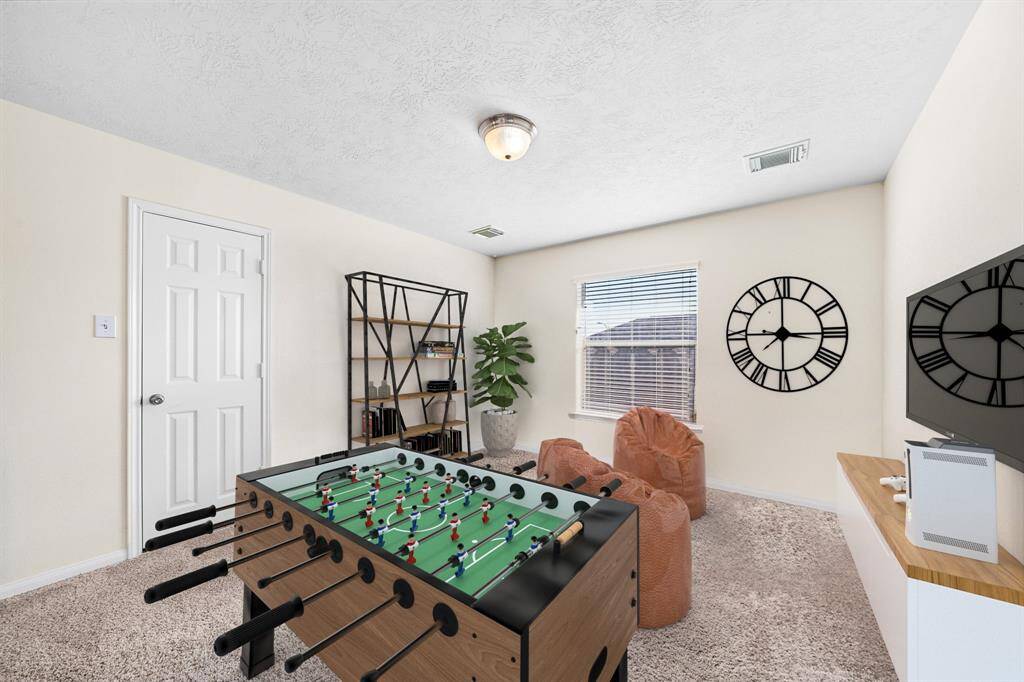 The flex space offers versatility for a game room or office, featuring plush carpeting and ample natural light from large windows. With its thoughtfully designed interior, this room provides a comfortable setting for relaxation or productivity, enhancing the home's functionality. This photo has been virtually staged.