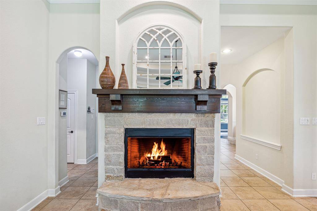 Austin Stone Gas Log Fireplace that is a Focal Interest for the Room * Huge Wood Mantel * Arched Opening on Left Leads to the Primary Bedroom and Utility Room and Garage.