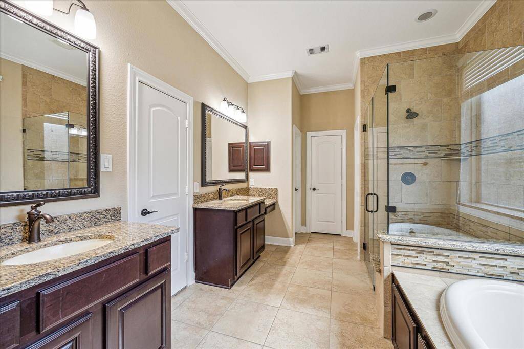 Primary Bathroom * Separate Sinks and One Has a Vanity for Seating * 2 Walk In Closets * All Neutral * Decorative Backsplash Around the Shower and Tub.