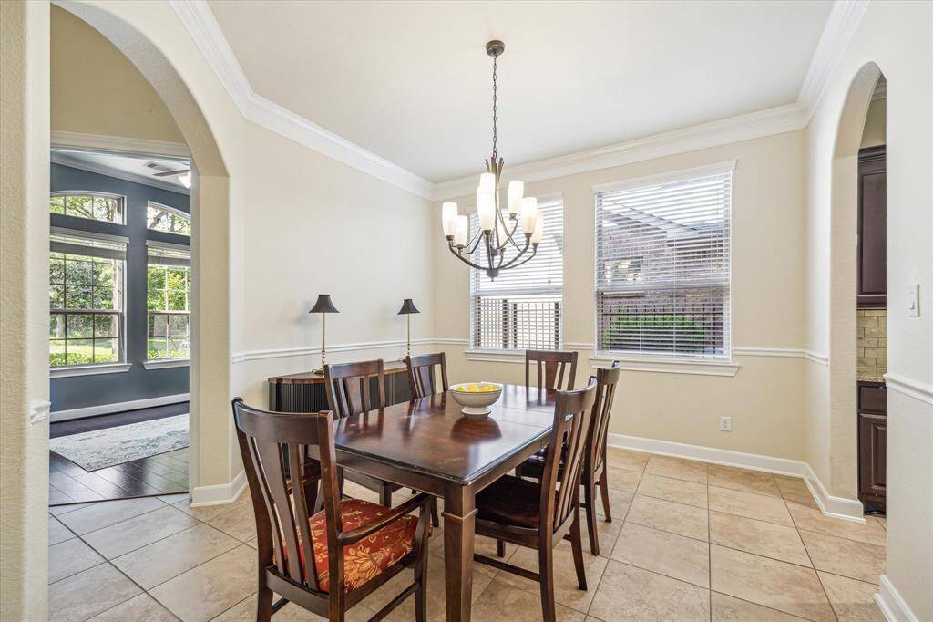 Dining Room * Crown Molding * Designer Chandelier will Remain * Wainscotting * Oversized Neutral Tile Floors * Arches.
