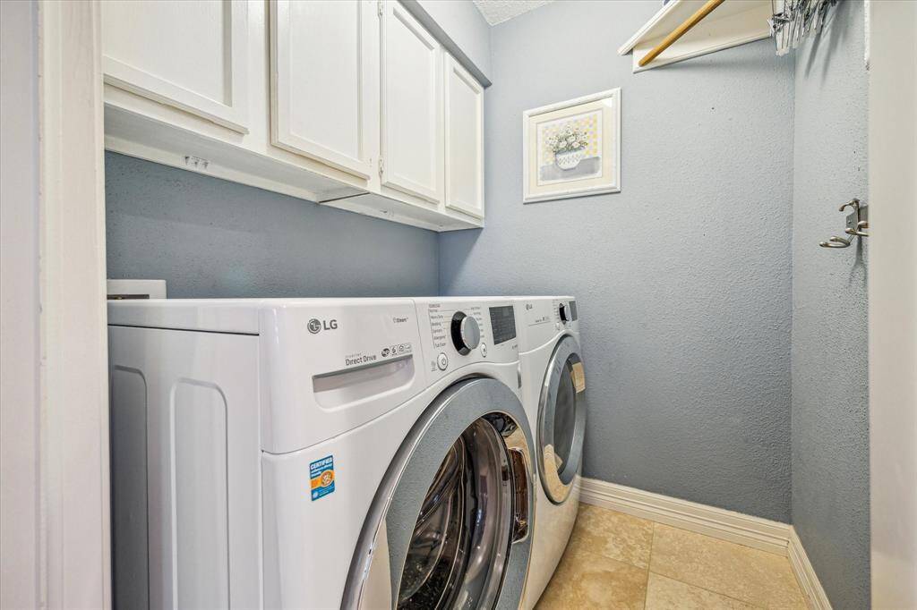 The utility room features tile flooring, a hanging bar, and overhead storage. *Water tank was replaced in 2018, and the A/C condenser was replaced in 2022. *per seller