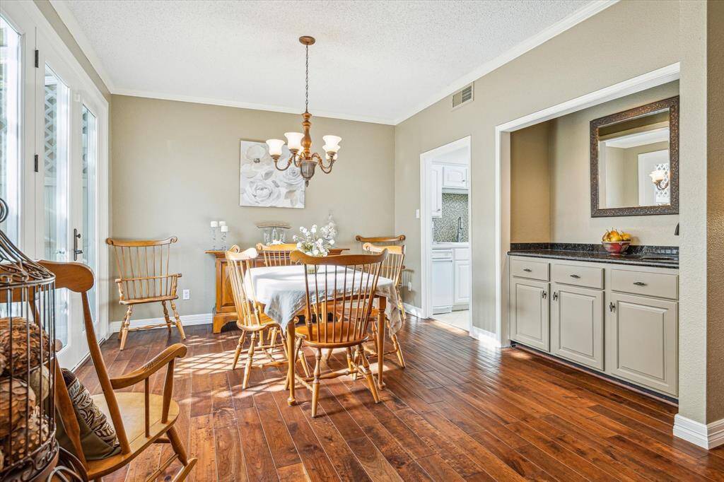 The dining room with a wet bar is conveniently located between the kitchen and the living room, allowing for ease of living and entertaining.