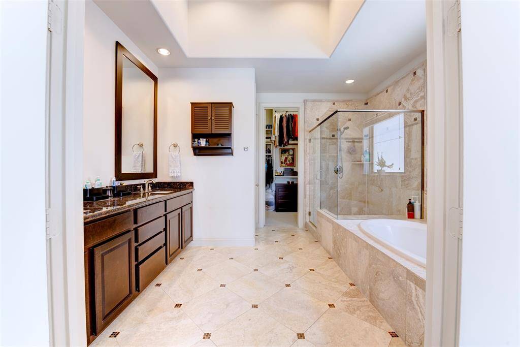 Large primary bathroom with a frameless shower, double sinks and a soaking tub.