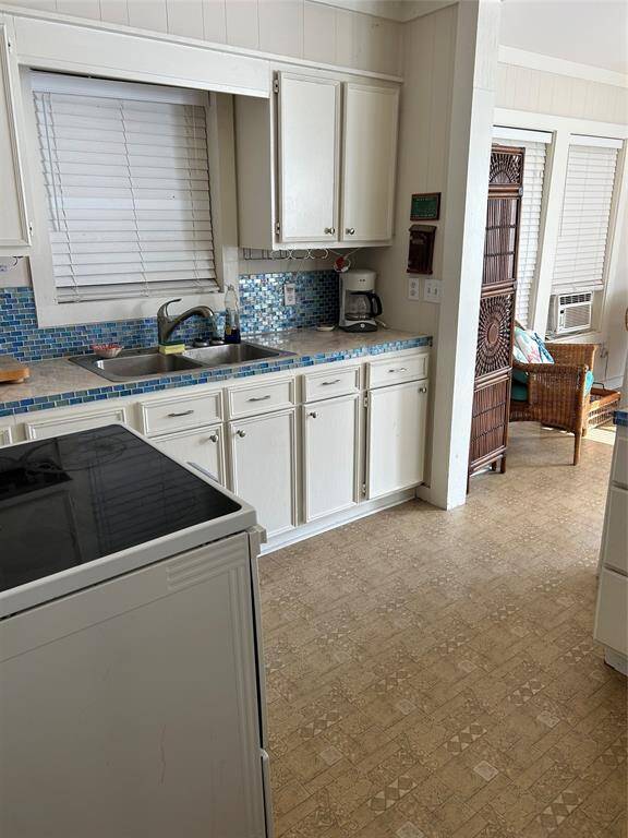 The kitchen has tile counter and iridescent backsplash.