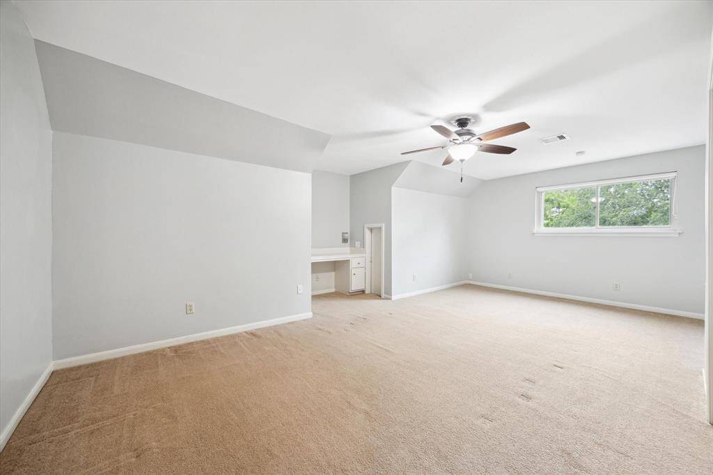 The fourth bedroom boasts a built-in desk area and direct attic storage access.