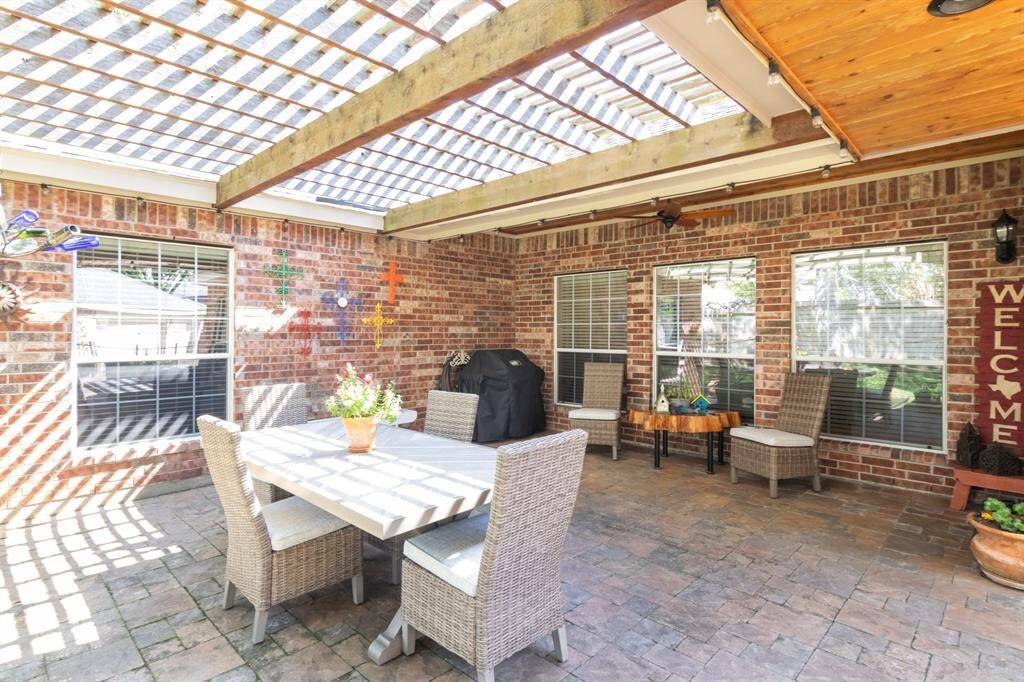 This patio and backyard were made for entertaining! Plenty of space for a patio table and other entertaining areas as well. There's a pretty pergola over the patio table space too.