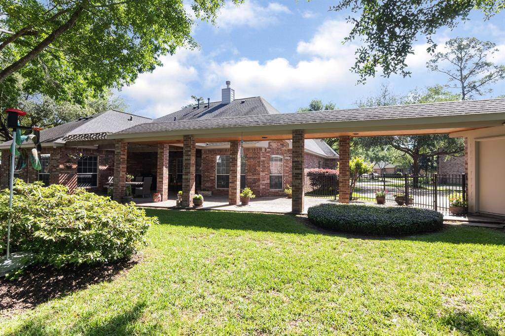 The backyard is HUGE and loaded with beautiful landscaping and trees! The long breezeway takes you into the side garage door.