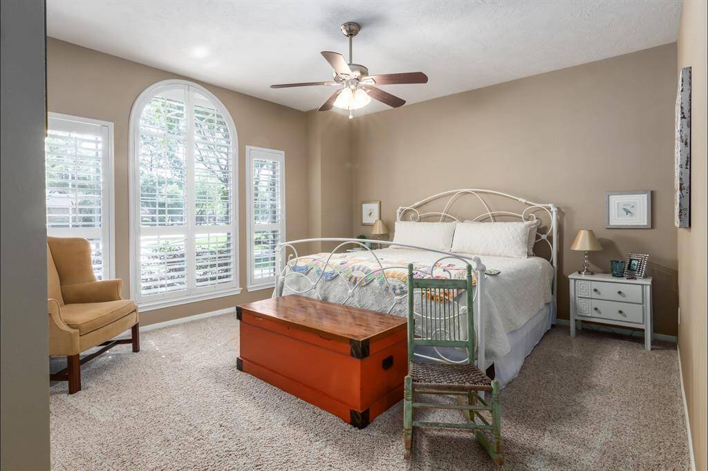 Also off the entry, you find a bedroom overlooking the front yard. The secondary bedrooms in this home are super spacious and can easily accommodate a king size bed. Pretty arched windows brighten this room. Plantation shutters on all front yard facing windows.