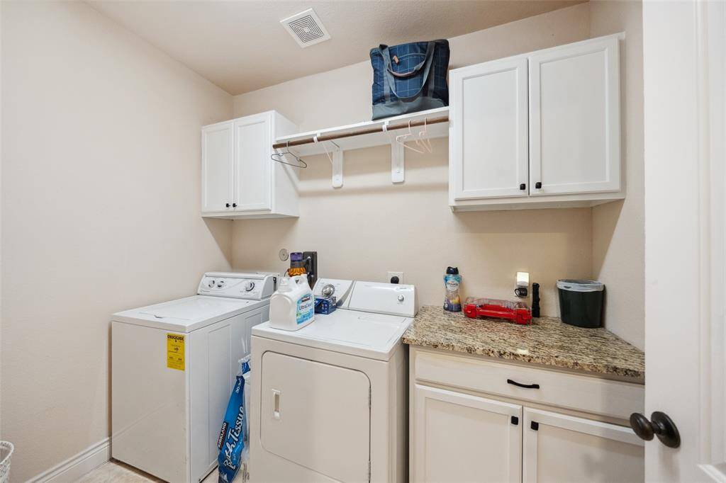 First floor laundry room with cabinet storage as well as hanging rack.