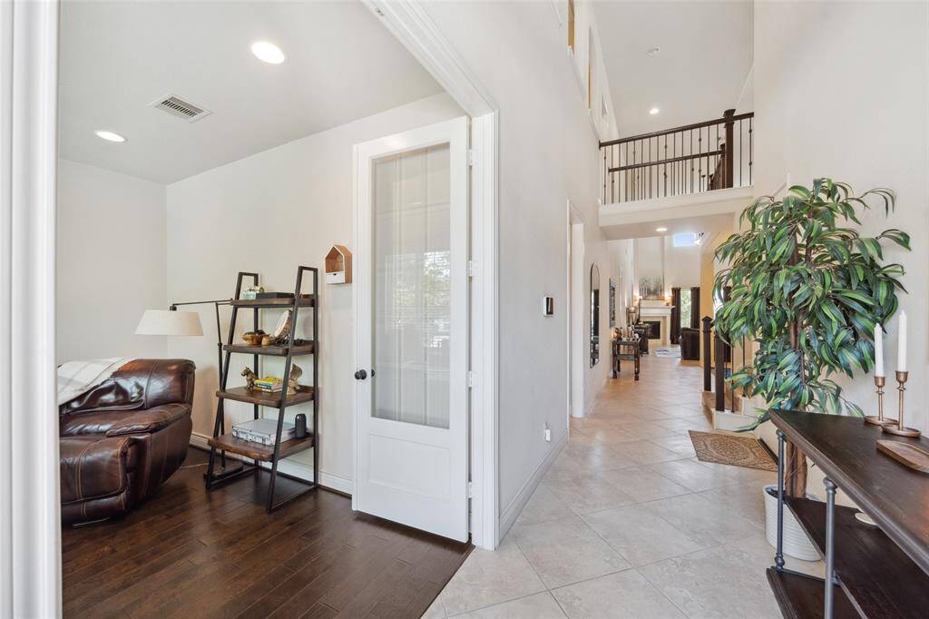 Front door opens to an entry foyer with home office to the left. Glass doors offer privacy while providing a view to the foyer.