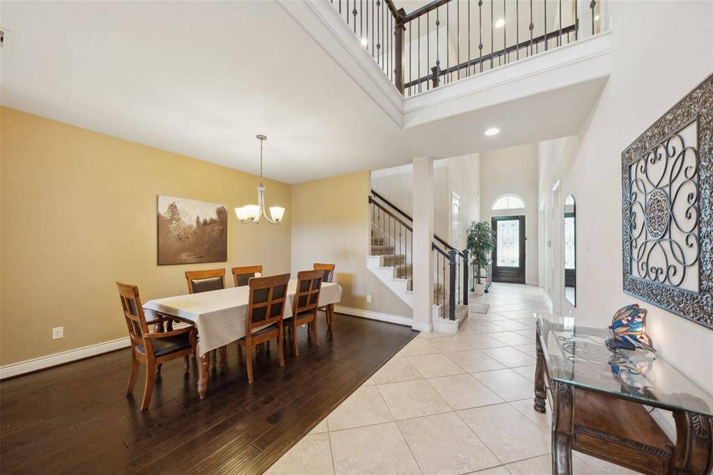 A look at the formal dining space set off by the wood flooring and lower ceiling. Entry foyer is beyond.