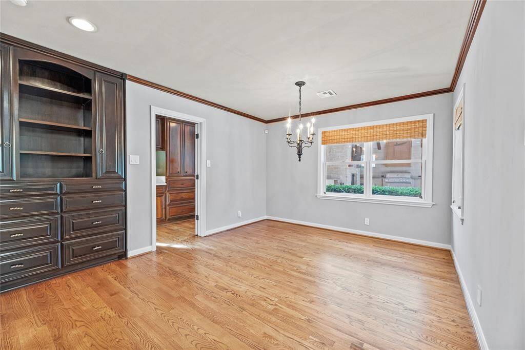 Elegant breakfast room with crown molding, built-in cabinetry, and abundant natural light with tranquil views of the backyard sanctuary