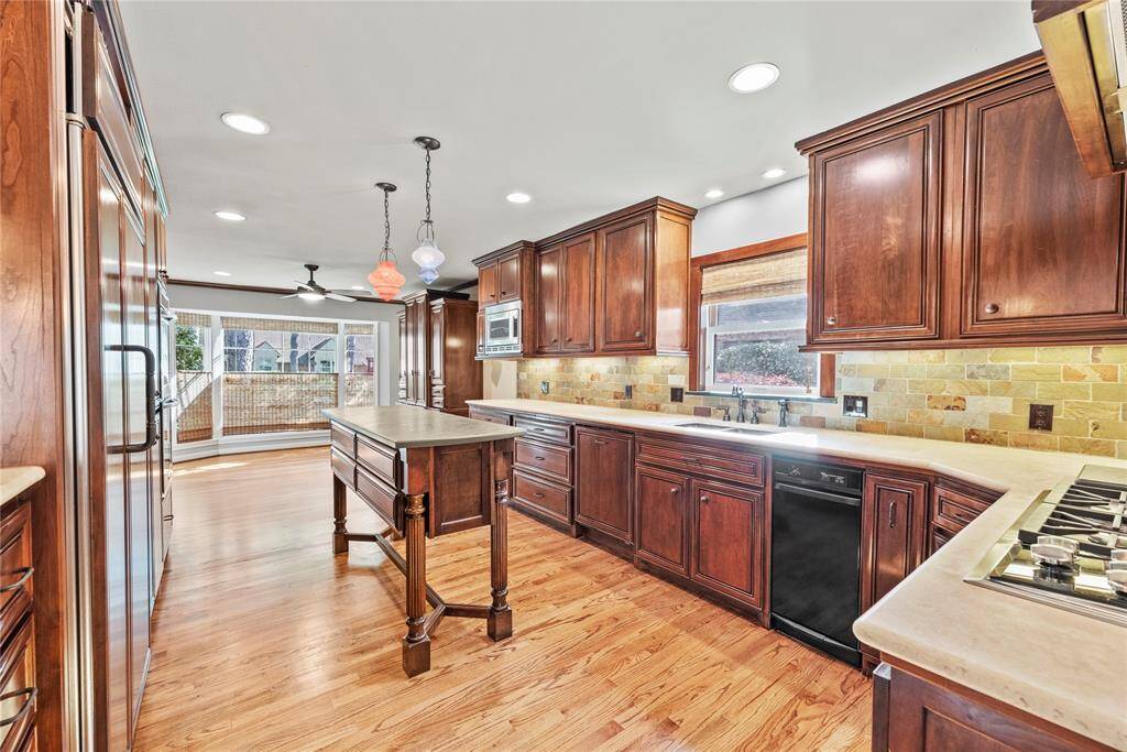 Expansive kitchen with a functional custom-made center island finished with slate top, perfect for food prep or serving. Classic finishes and generous counter space make this kitchen as beautiful as it is practical.