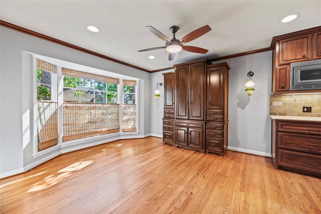 Charming sitting area just off the kitchen ideal for morning coffee or evening reading. Custom cabinet flanked by elegant Murano glass sconces.