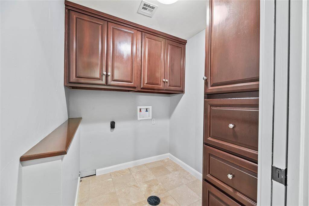 The custom cabinetry is continued in this well-appointed laundry room and features a hidden laundry shoot originating from the upstairs bathroom!