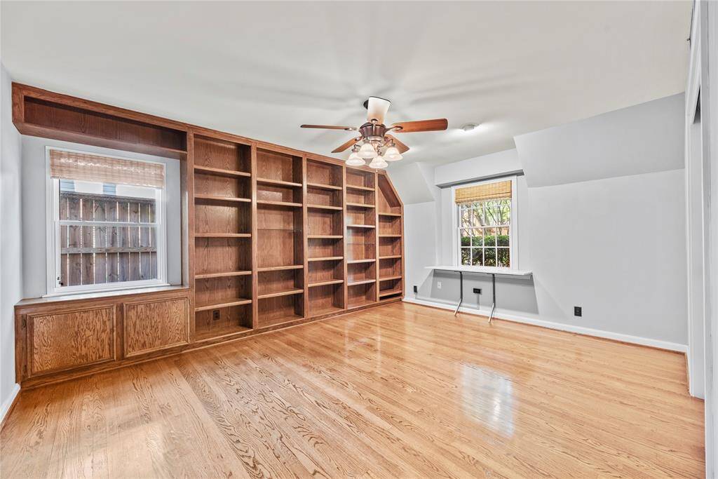 Secondary bedroom, flex space or potential home office with floor-to-ceiling built-in bookshelves and hardwood floors ideally positioned on the 1st floor