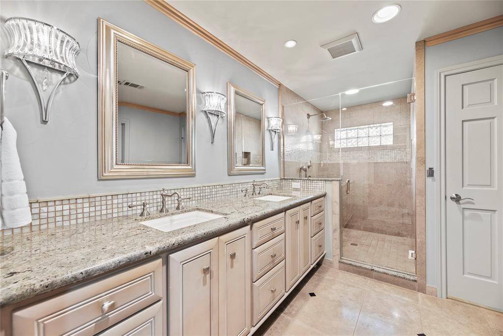 A secondary look at the elegant primary bath, showcasing beautiful custom cabinetry and timeless tile finishes.